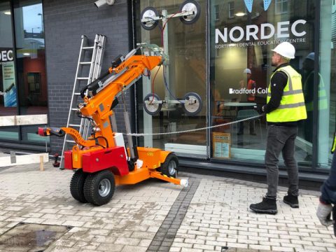 A Smartligt glazing robot lifting a large pane of glass.